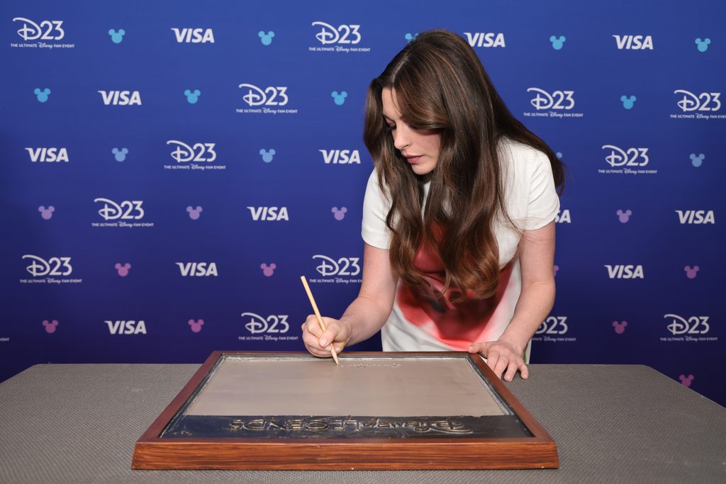 授賞式で、レジェンドの名を刻む銘板の原型に手を入れるアン・ハサウェイ（©Image Group LA / The Walt Disney Company）